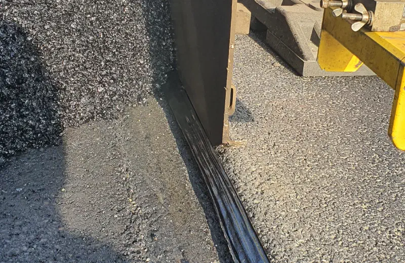 Der Fertiger arbeitet an der Kante des benachbarten Fahrbahnstreifens.